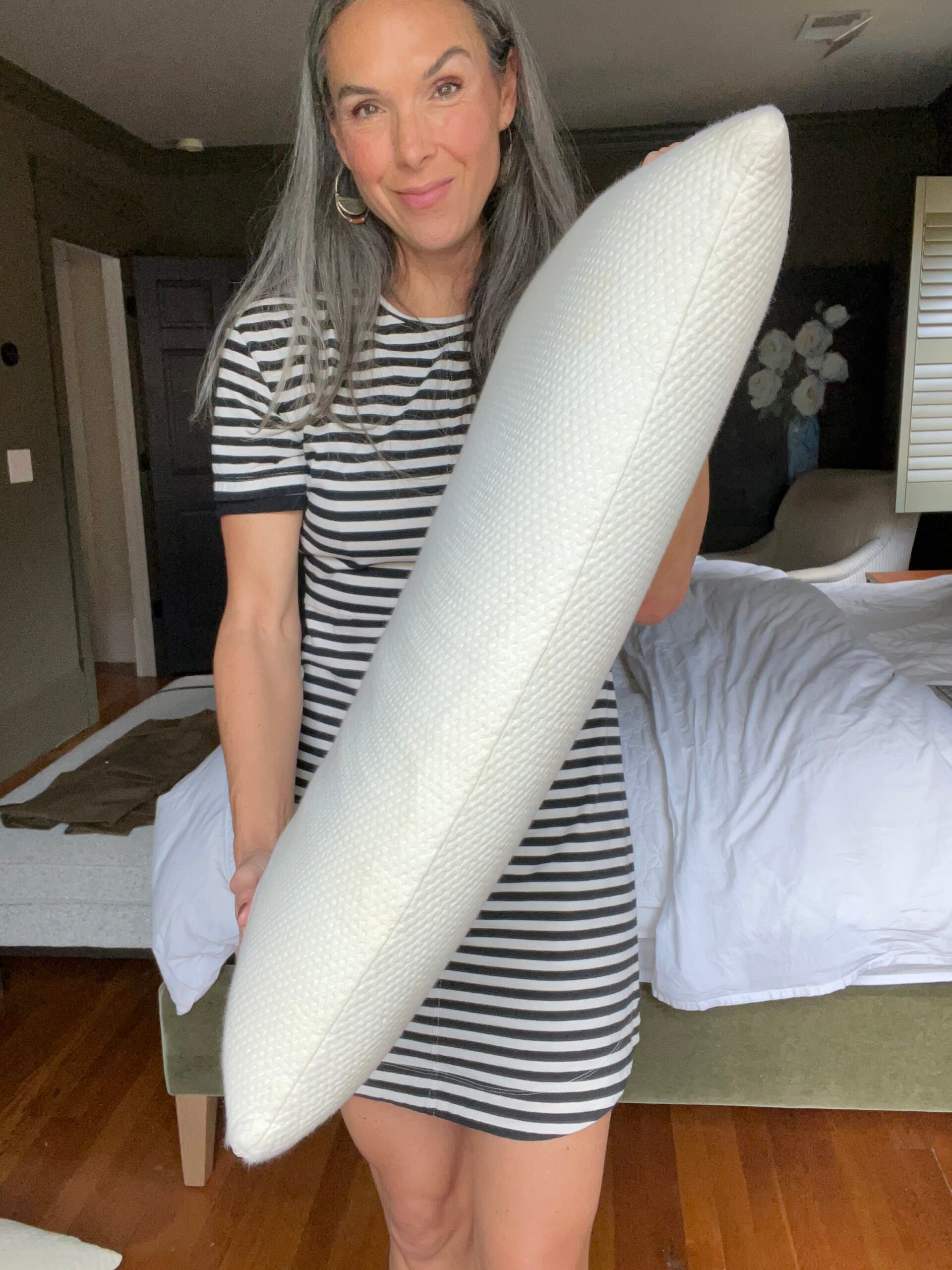 A woman holds up a pillow from Essentia