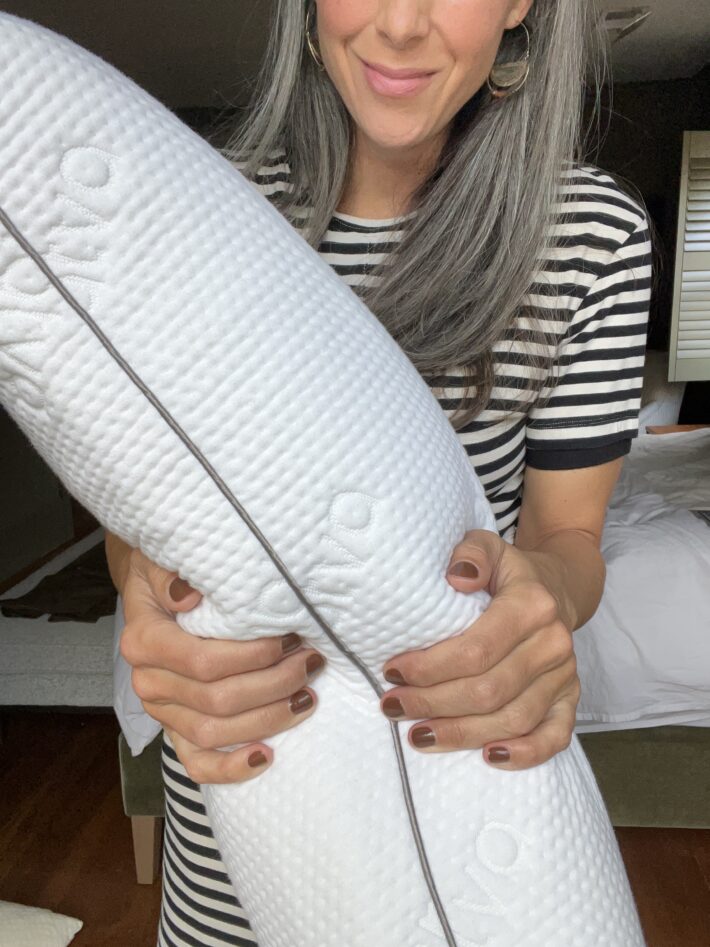 lisa holds the saatva memory foam pillow
