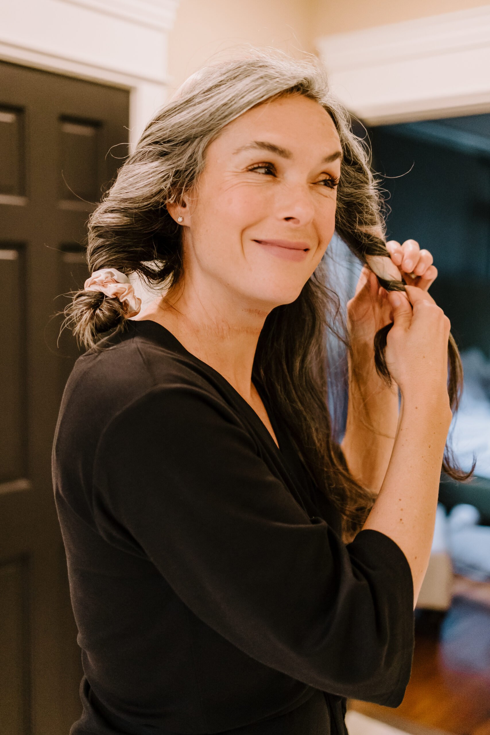 A woman with long wavy gray hair takes out her Kitsch heatless curling set.