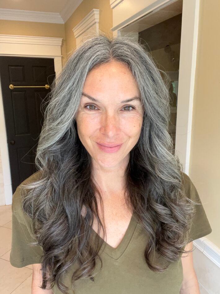 A woman with long gray hair after styling her hair with the Dyson Airwrap
