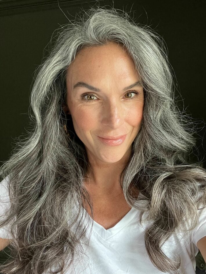 A woman with fully styled gray hair after using Dyson Airwrap's 1.2 inch long barrel.
