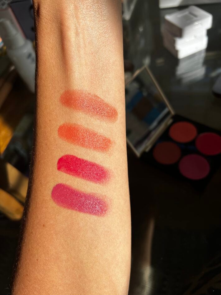 The Fitglow multi-stick palette includes four new shades: Mauve Berry (creamy mauve berry), Sun Peach (soft peach), Watermelon (soft rose) and Fig (soft raisin rose) pictured on a woman's arm here..