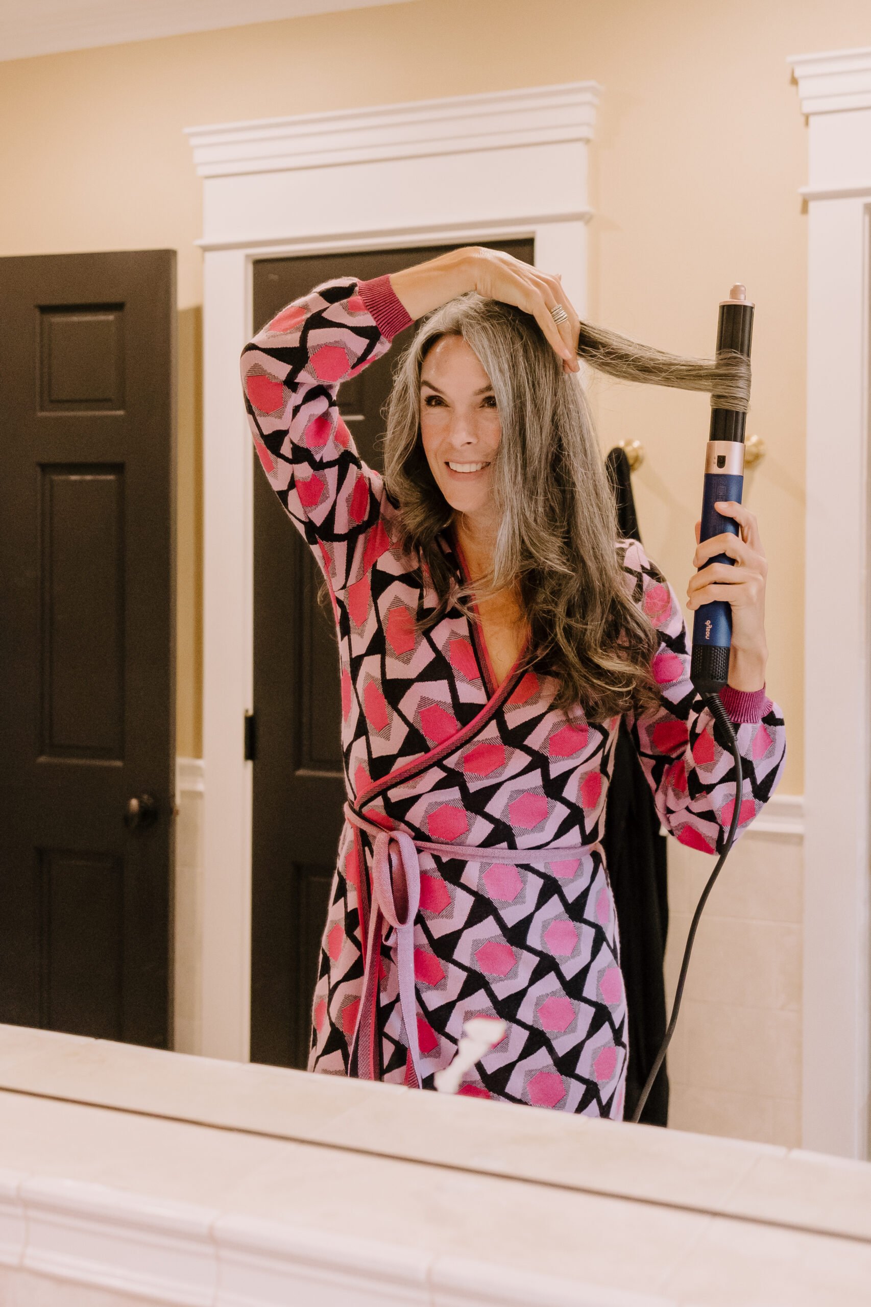A woman styles her hair with the Dyson Airwrap.