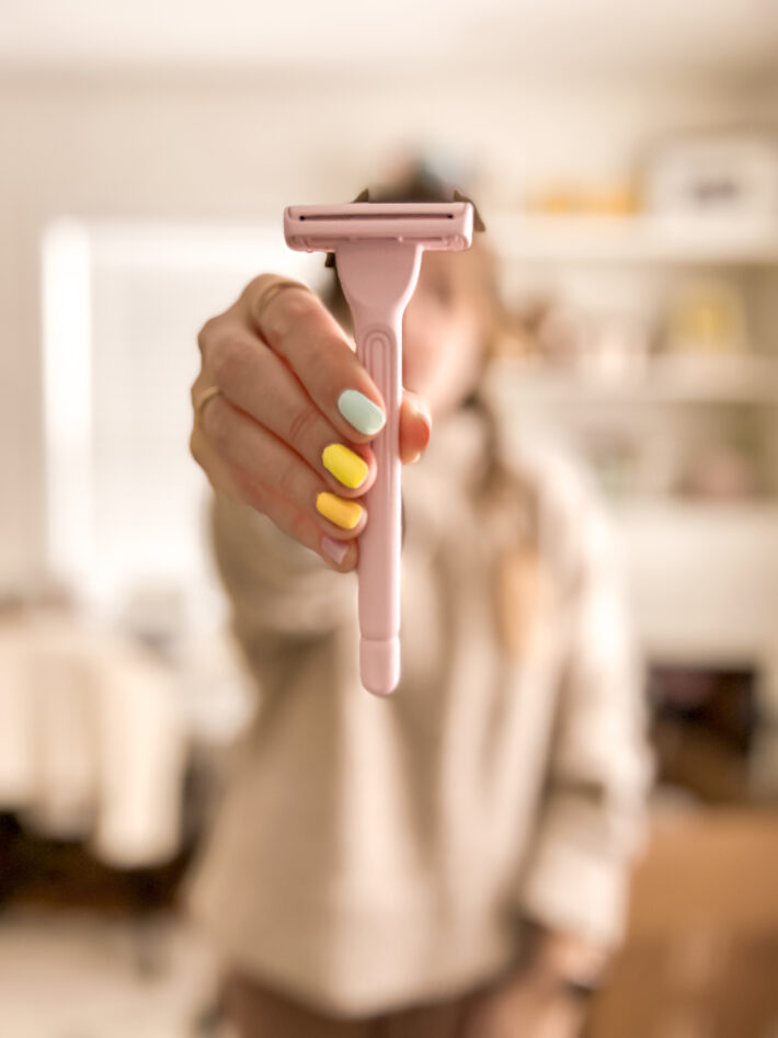 A woman holding up the Hanni razor.