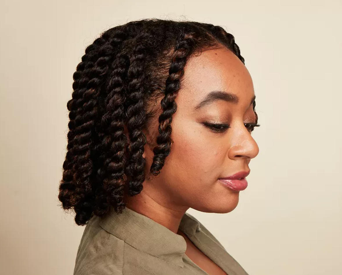 The side profile of a woman with long black twists. 