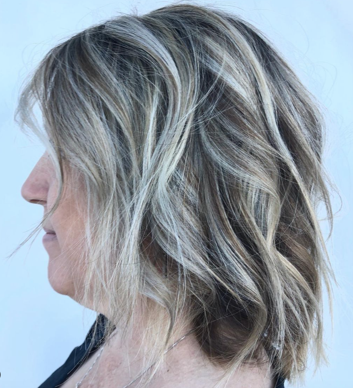 The side profile of a woman with a layered haircut.