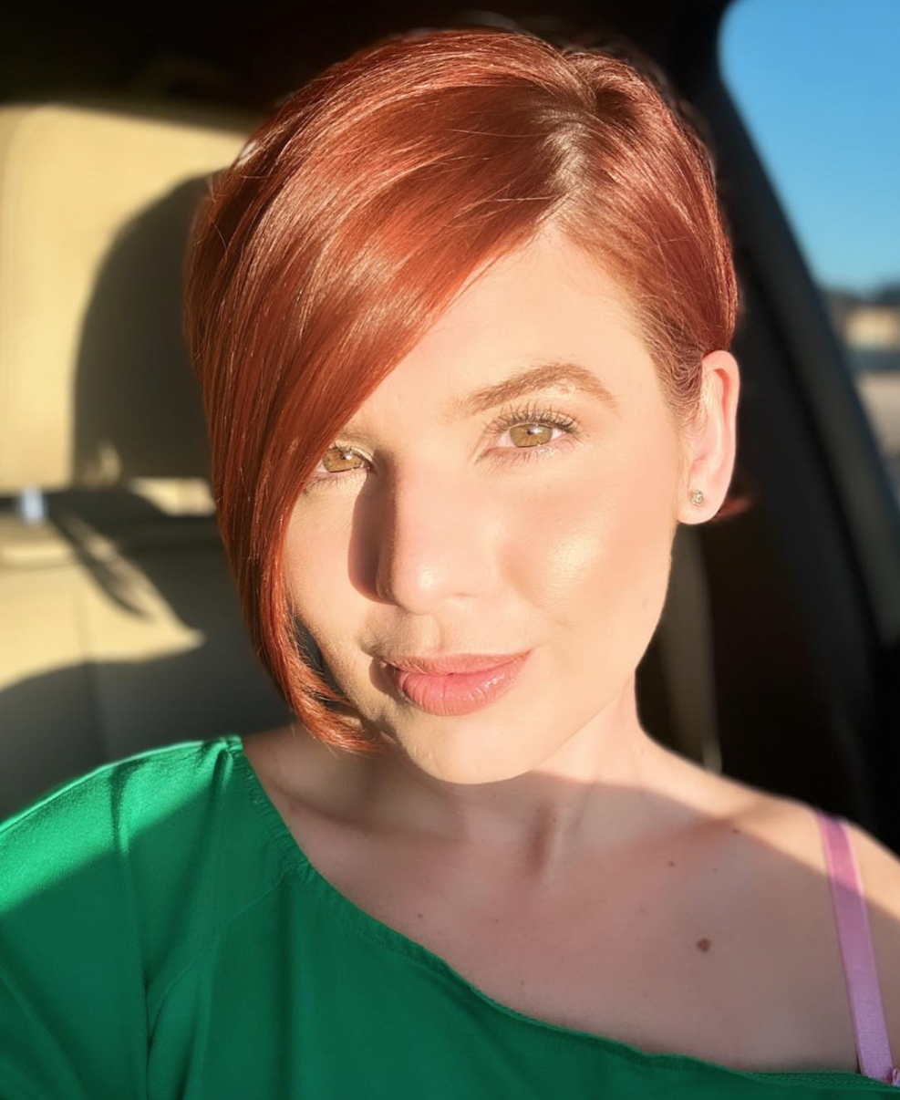 A woman with a sleek haircut for her red hair. 