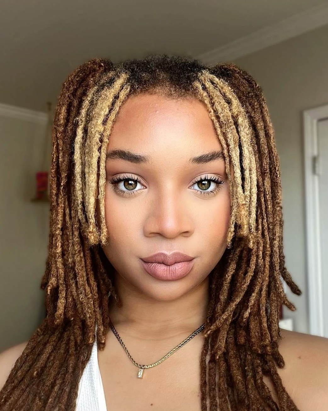 A straight on view of a woman with dreadlocs.