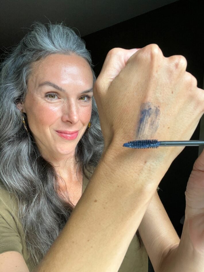 A woman applies Fitglow Good+ mascara to her hand.