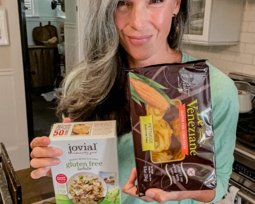 A woman holds up gluten free food items.