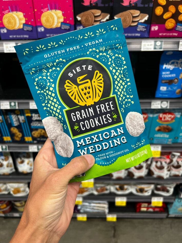 A hand holding up a bag of gluten free cookies.
