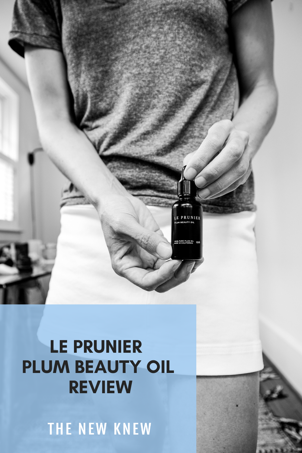 a black and white of me holding a bottle of Le Prunier