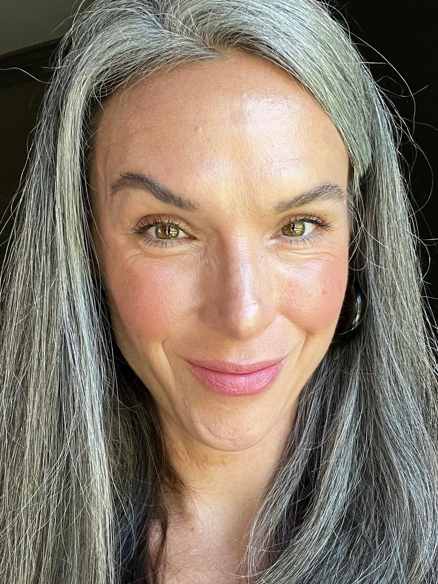 A woman with long straight gray hair