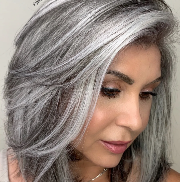 A woman looking down who has gray hair.