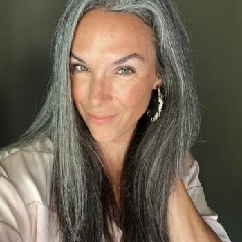 A headshot of a woman with long gray hair.