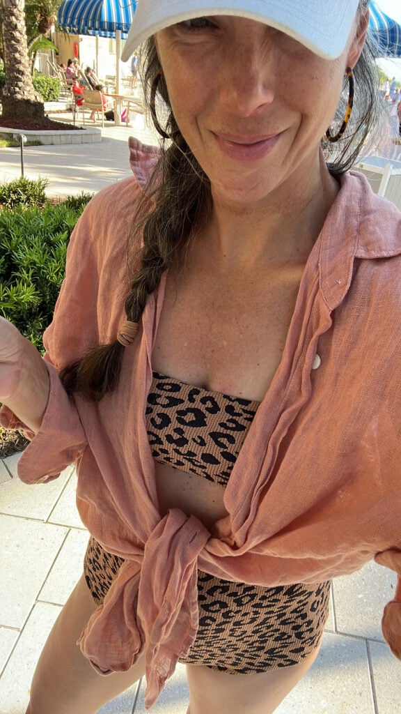A woman in a leopard bikini and linen coverup.