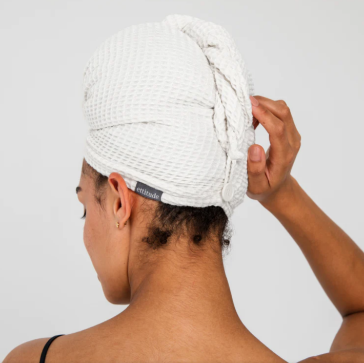 The backside of a woman's head wearing a hair towel. 