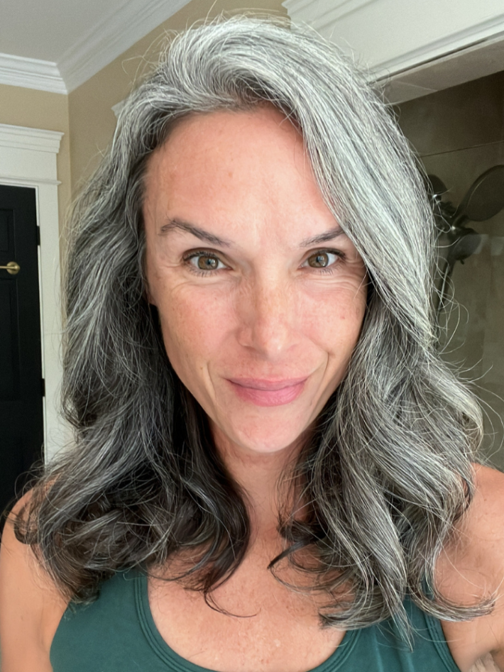 A woman with gray hair after styling with the Shark FlexStyle. 