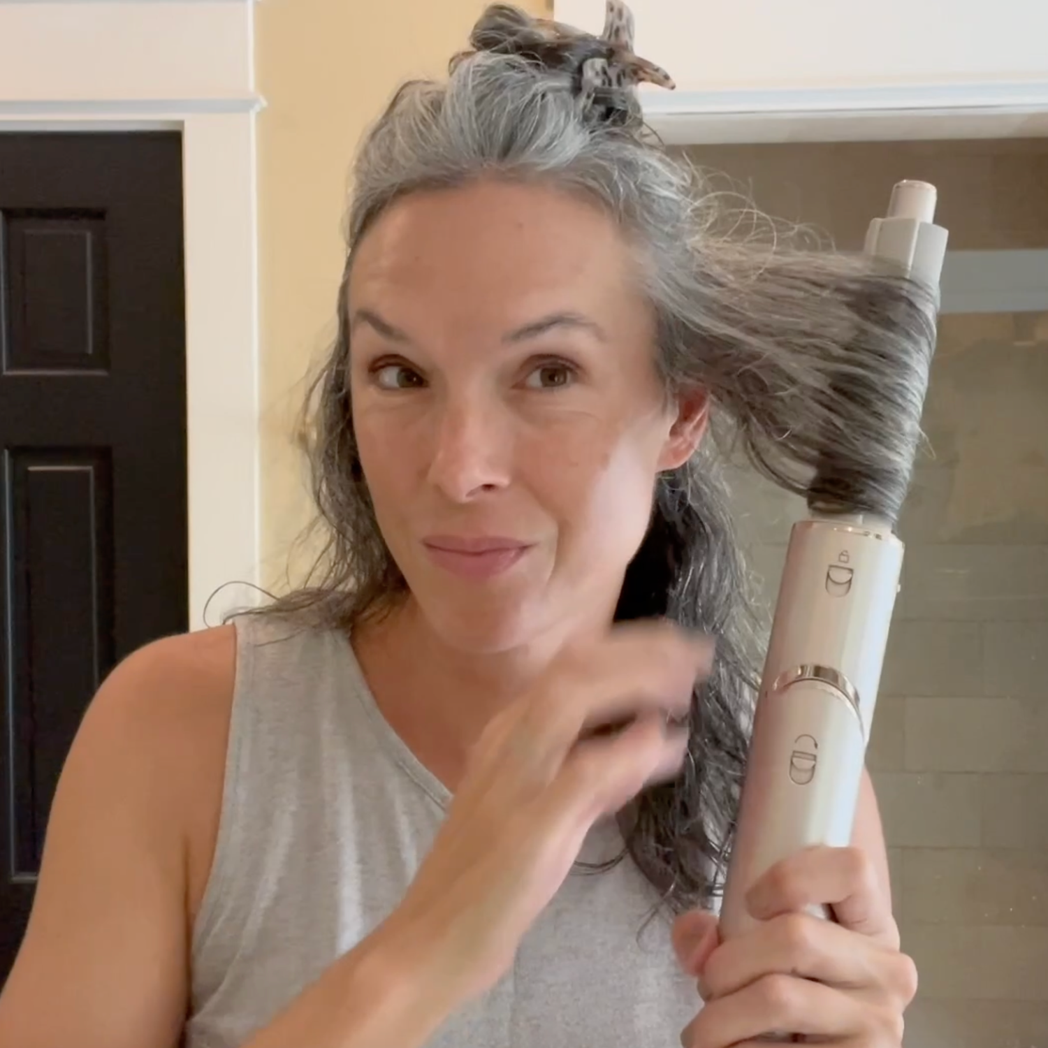 A woman with gray hair styling with the Shark FlexStyle.