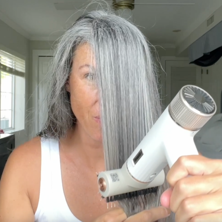 A woman with gray hair using the SpeedStyle.