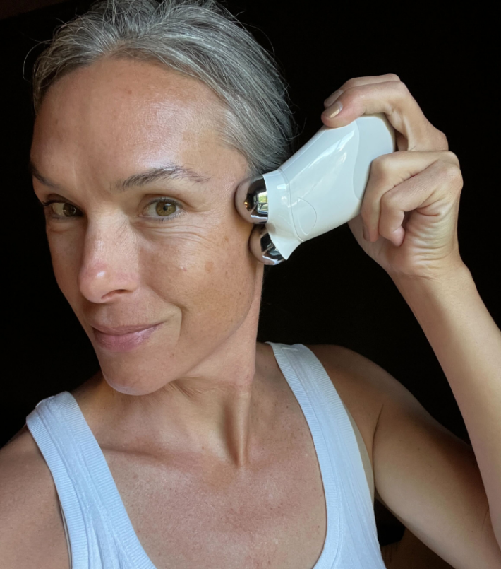 A woman with a NuFACE facial toning device. 