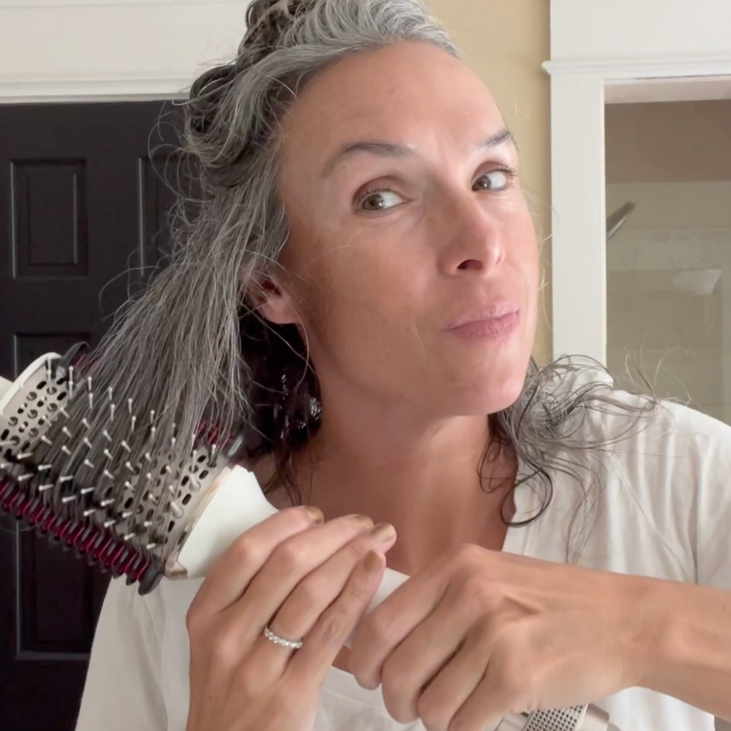 A woman styling her hair with a Shark hair tool. 