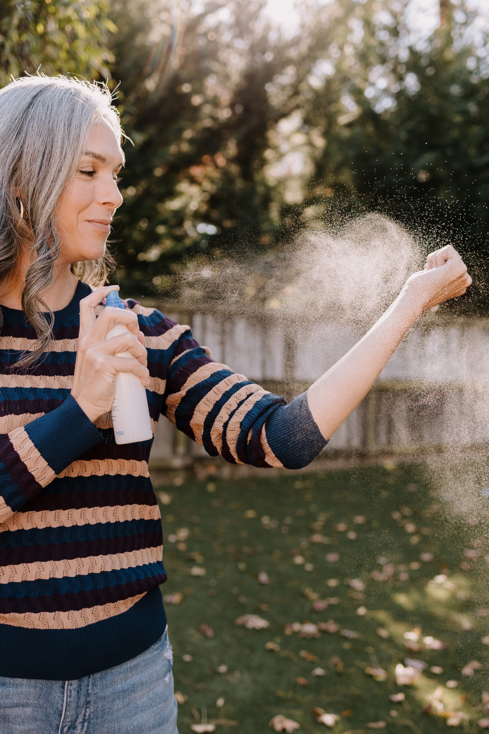A woman sprays Magic Molecule onto her arm.