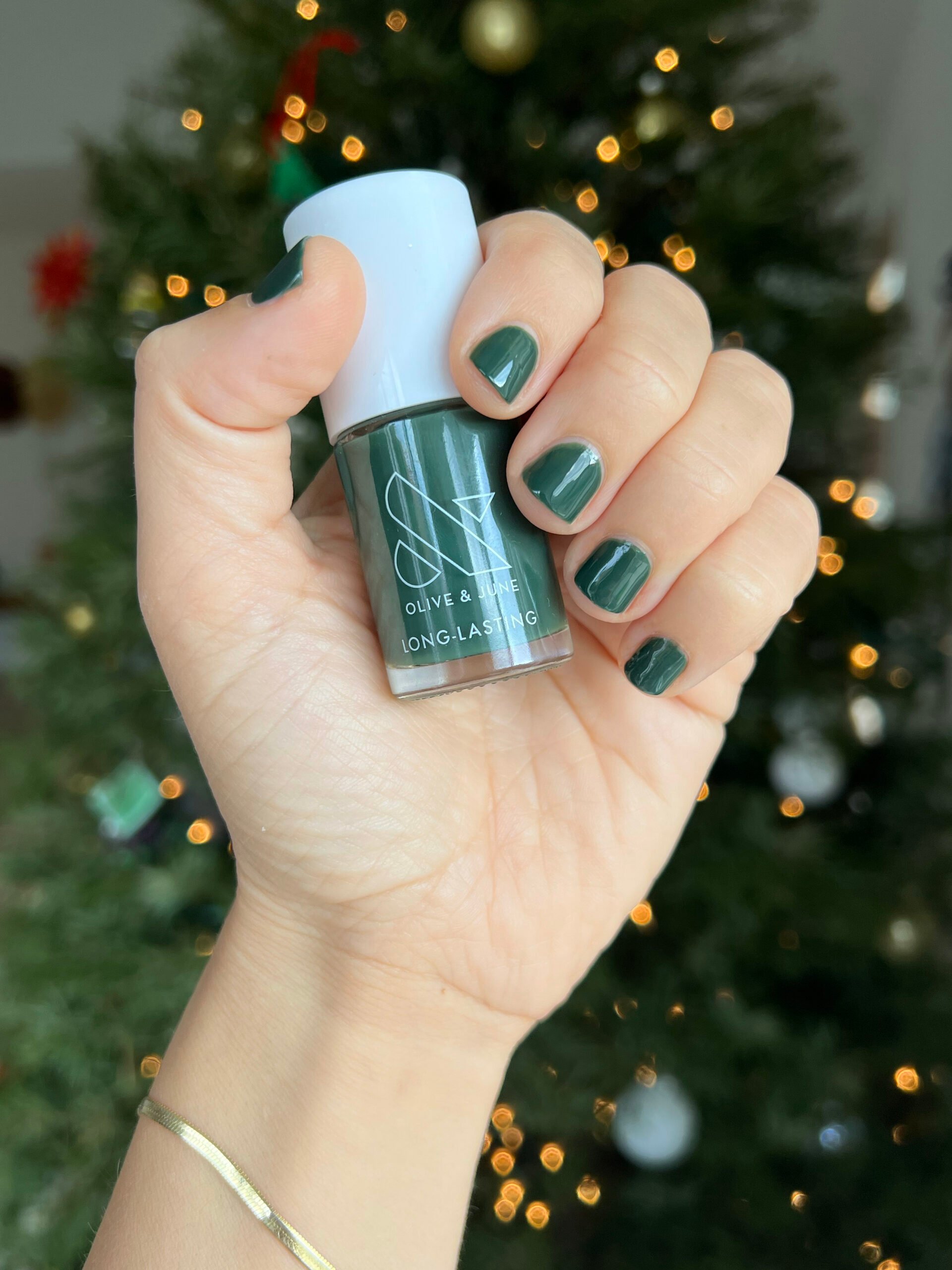 Olive & June dark green painted onto nails.