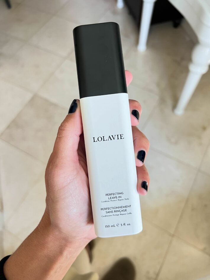 LolaVie perfecting leave-in in a woman's hand.