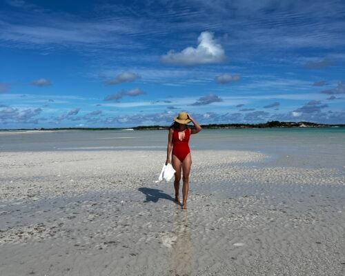 A woman walks along the beach.