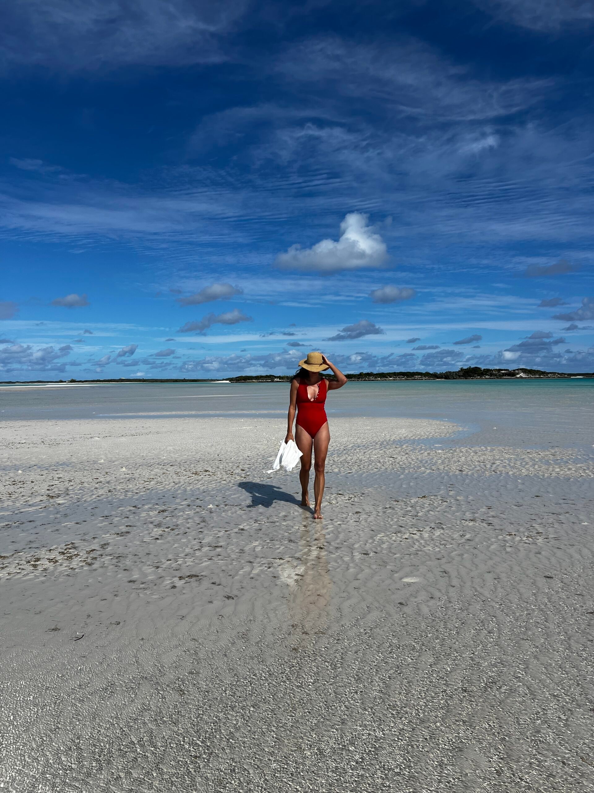 A woman walks along the beach.