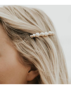 A pearl clip in a person's hair.