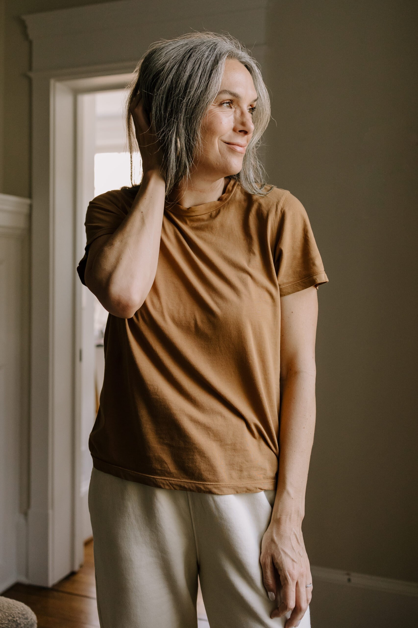 A woman in a dusty red brown t-shirt. 