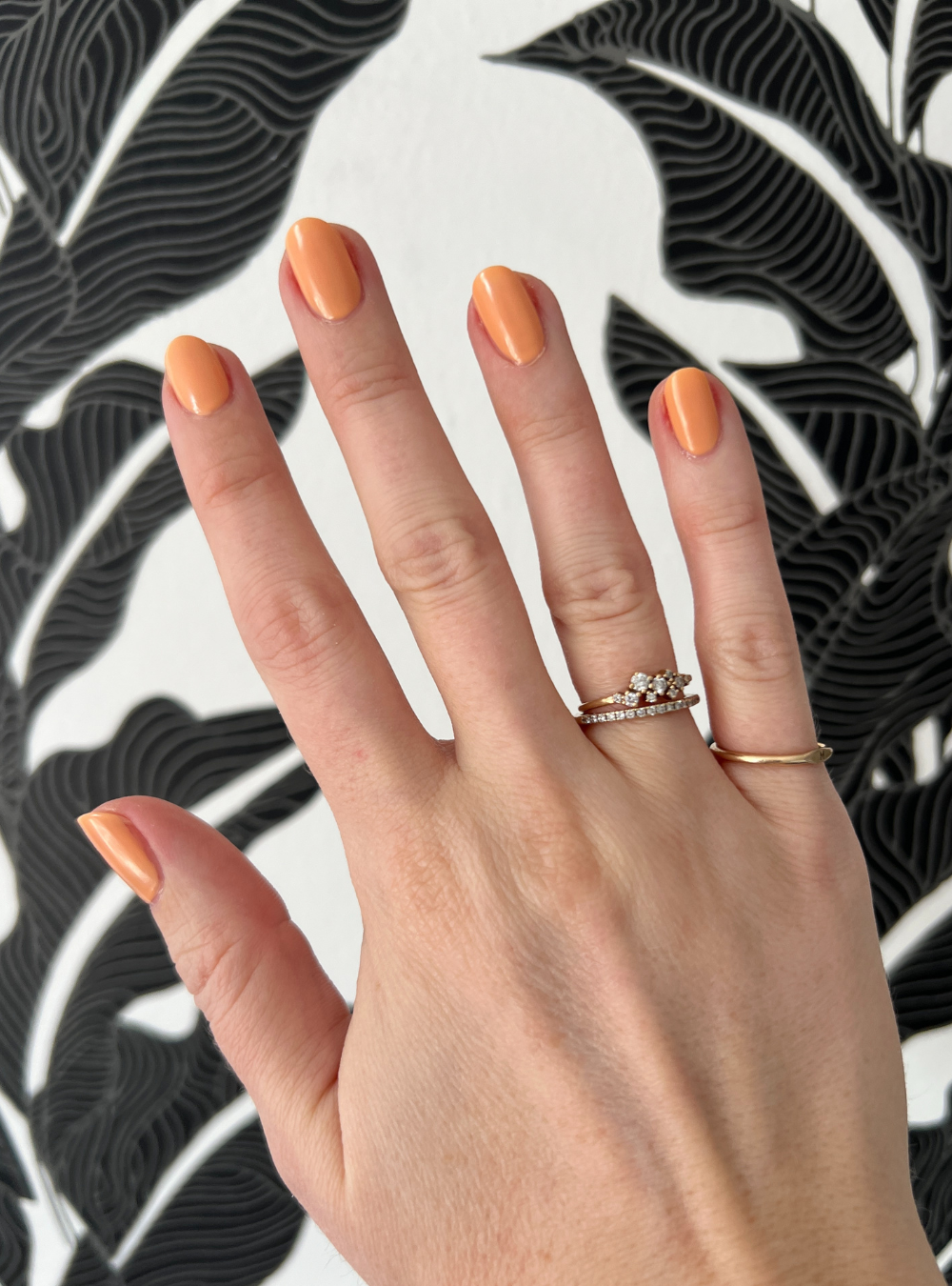 A close up of hand painted with orange nail polish.