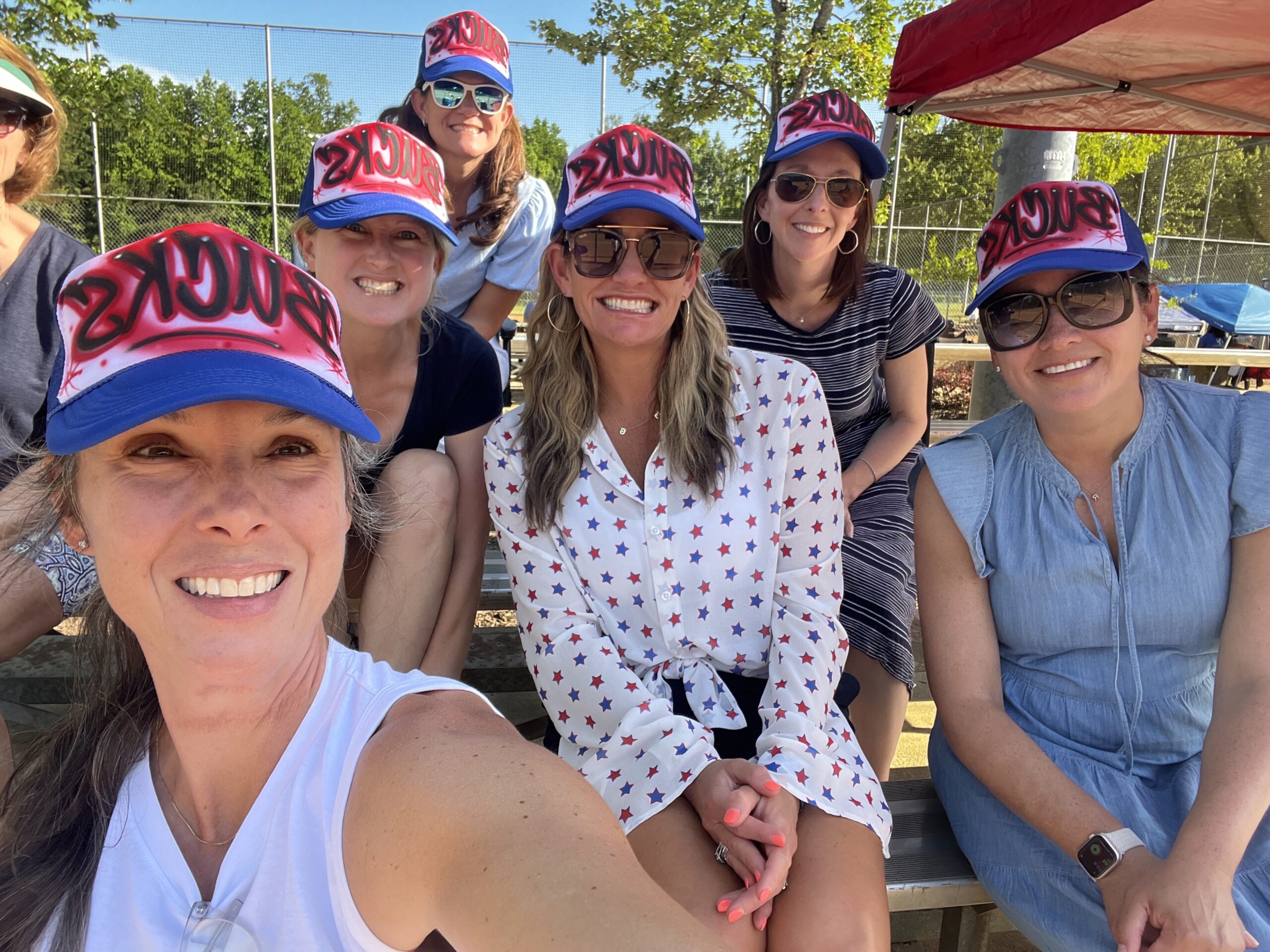 A group of moms in custom baseball hats. 