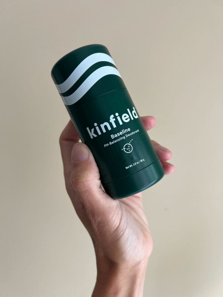 A container of Kinfield Baseline deodorant in a woman's hand.