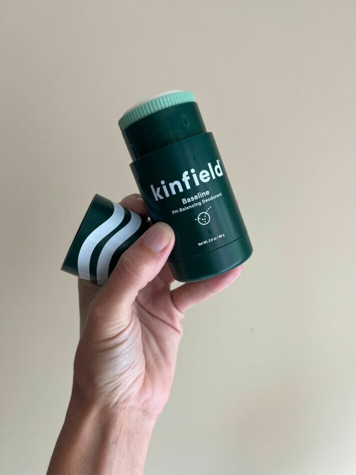 A tube of Kinfield deodorant in a hand.