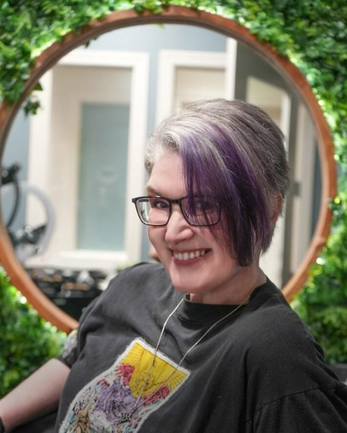 A woman with purple streaks in her short hair. 